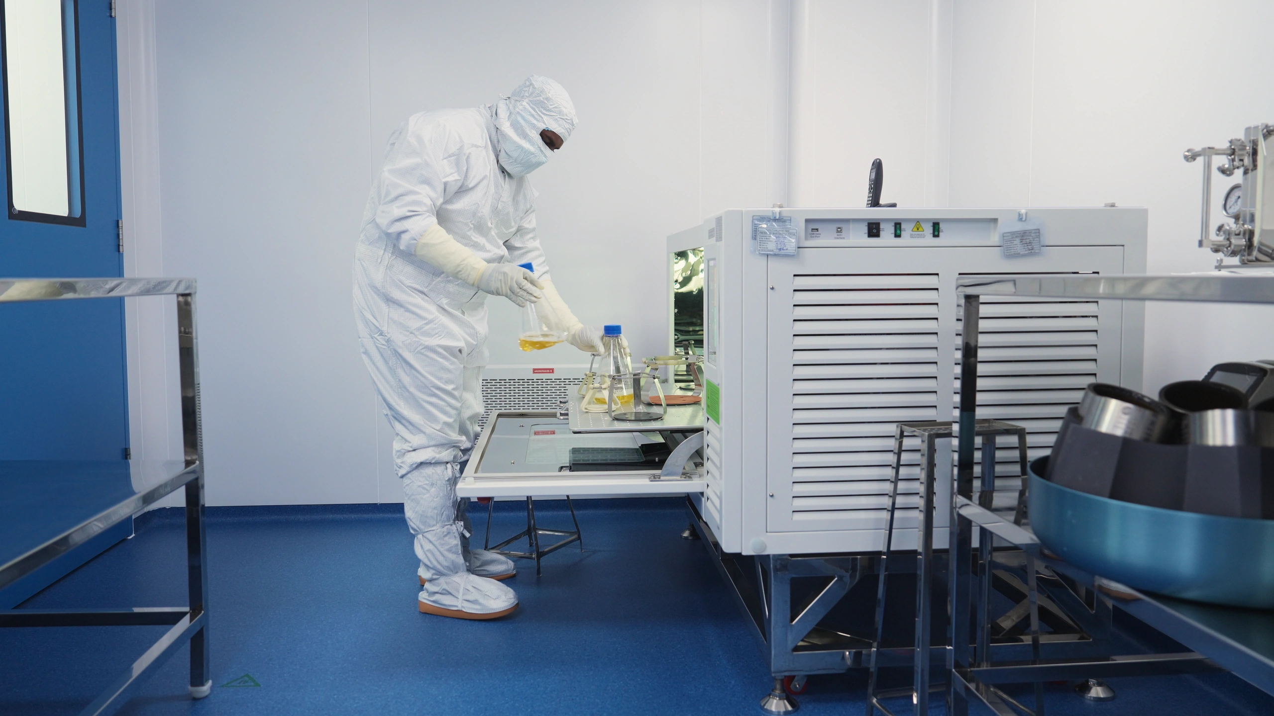 An operator loading flasks into a shaker at the RNA Foundry.